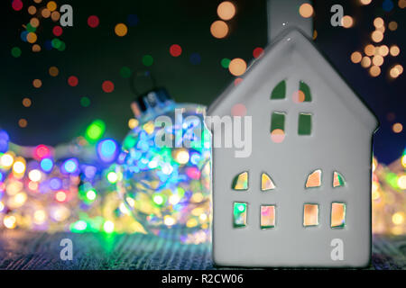 Dekorative christmas House gegen Hintergrund mit hellen bunten Lichter Girlande Stockfoto