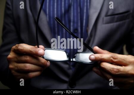 Foto von einem Mann in Anzug Brillen Holding Stockfoto