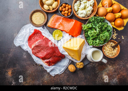 Ausgewogene Ernährung essen Hintergrund. Protein Lebensmittel: Fisch, Fleisch, Eier, Käse, Quinoa, Muttern auf dunklem Hintergrund, Ansicht von oben, kopieren. Stockfoto