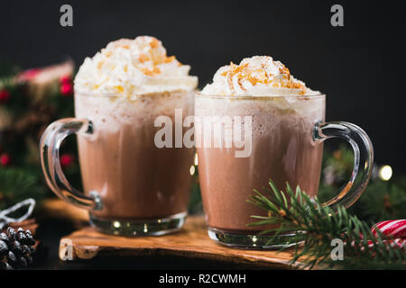 Weihnachten Heiße Schokolade mit Sahne in der Tasse. Zucker mit goldenen Sternen verziert. Festliche Weihnachts- oder Winterurlaub Trinken, Comfort Food Konzept Stockfoto