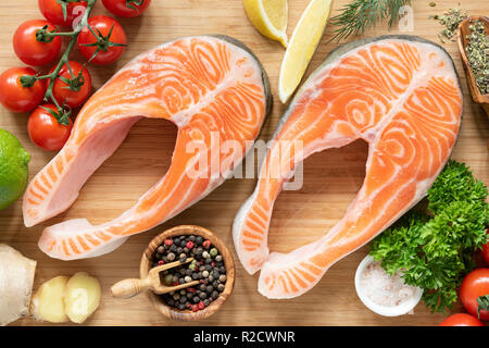 Frischer Lachs Steaks auf Schneidebrett bereit für das Kochen. Fisch, Gewürze und Gemüse Stockfoto