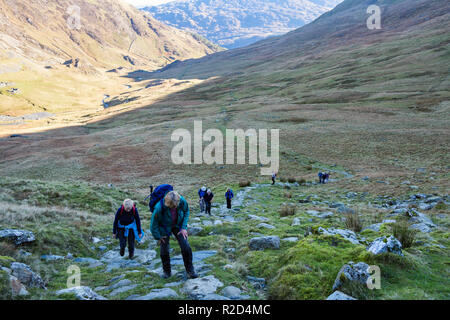 Wanderer Wandern bis Weg von Cwm Llançà an Hängen mit Yr Aran Berghang in Snowdonia National Park. Bethania, Gwynedd, Wales, Großbritannien, Großbritannien Stockfoto