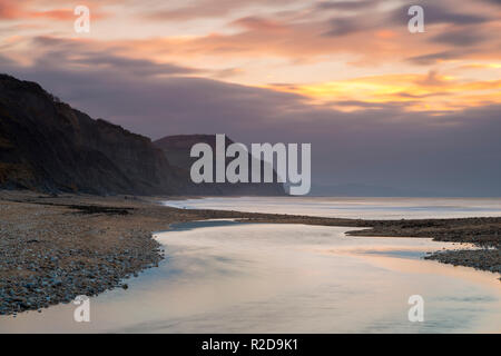 Charmouth, Dorset, Großbritannien. 19 Nov, 2018. Blick auf goldene Kappe von Charmouth Beach in Dorset wie Wolken im Osten bei Sonnenaufgang an einem kalten Morgen. Foto: Graham Jagd-/Alamy leben Nachrichten Stockfoto