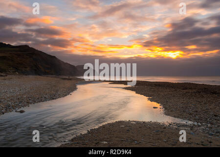 Charmouth, Dorset, Großbritannien. 19 Nov, 2018. Blick auf goldene Kappe von Charmouth Beach in Dorset wie Wolken im Osten bei Sonnenaufgang an einem kalten Morgen. Foto: Graham Jagd-/Alamy leben Nachrichten Stockfoto