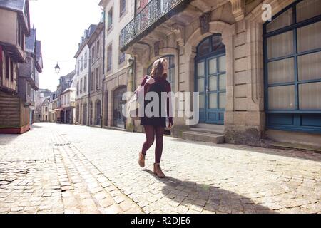 Mädchen entlang eine leere Straße in der Altstadt Morlaix. Frankreich Stockfoto