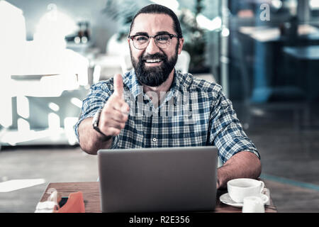 Dunkle Bärtigen-eyed Geschäftsmann zur Genehmigung der Arbeit seiner Mitarbeiter Stockfoto