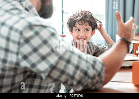 Bärtige Vater tragen Hand beobachten. weitererzählen, sein Sohn Stockfoto