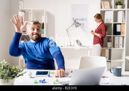 Verspielte Programmierer werfen Papier Kugel Stockfoto