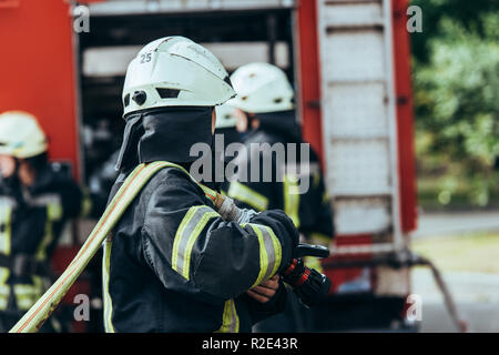 Teilweise mit Blick auf die Einsatzkräfte der Feuerwehr und Feuer-LKW auf der Straße Stockfoto