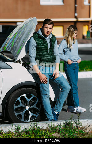 Verärgert junges Paar in der Nähe von Broken Auto auf der Straße Stockfoto