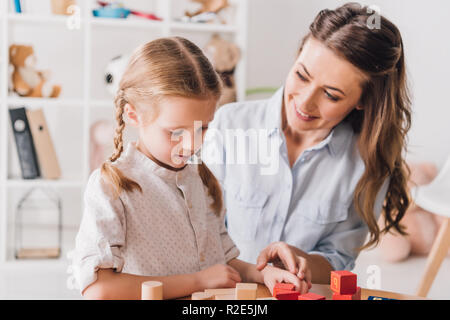 Glückliche Mutter spielt Bausteine mit Kind Stockfoto