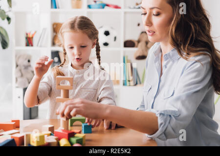 Mutter spielt Holzblöcke mit kleinen Tochter Stockfoto