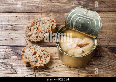 Zinn öffnen können mit rosa Lachs Fisch und Stücke Brot auf hölzernen Hintergrund Stockfoto