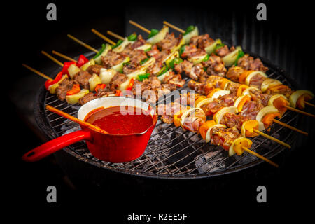 BBQ Beef Grill Steak mit Eintauchen seasoning Sauce in der heißen Kohle Herd. Stockfoto