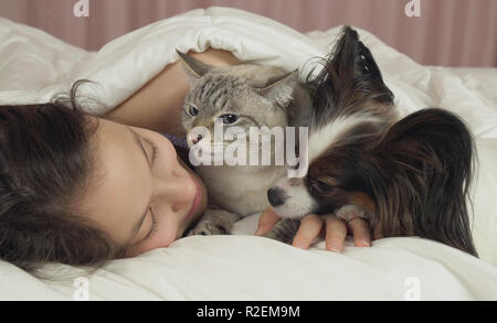 Schöne jugendlich Mädchen süß schlafen im Bett mit Hund und Katze Stockfoto