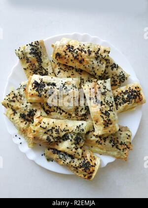 Cutted lavash Stücke mit Gemüse auf dem Teller. Burek mit Spinat und Käse und schwarzer Kreuzkümmel. Yufka Stockfoto