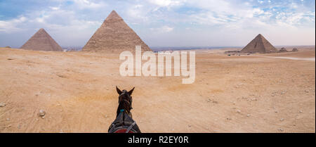 Abend Wüste und Pyramiden von Gizeh mit einem Pferd im Vordergrund, keine Touristen, in der Nähe von Kairo, Ägypten. Große Pyramide von Gizeh, Pyramide von Khafre, die zum UNESCO-Weltkulturerbe zählt. Stockfoto