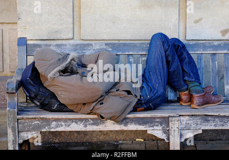 Obdachloser schlafend auf Holzbank, Cambridge, England Stockfoto