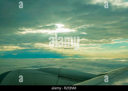 Wunderschöne Aussicht auf Wolken und Himmel mit Sonnenlicht am Morgen durch ein Flugzeug Fenster Stockfoto