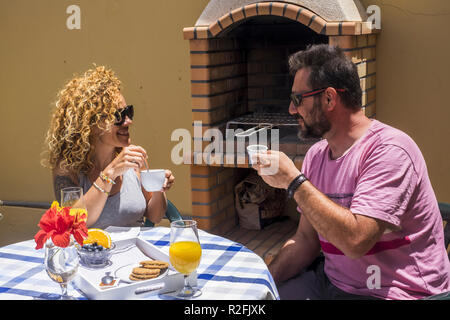 Schöne fröhliche kaukasischen Paar frühstücken zu Hause in der Nähe von einem Grill Grill outdoor. Lächeln und verbrachte Sime gute Zeit zusammen für erwachsene Paare. Stockfoto