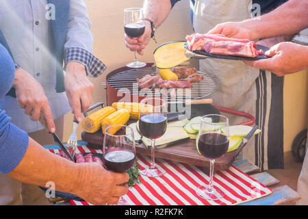 Aus der Nähe mit einer Menge alter Händen zubereitete Mahlzeit mit Grill im Freien. frische Lebensmittel wie Mehl und Gemüse und Mais Mais gekocht auf die Flamme Pop. Gruppe von Menschen in Nizza Aktivität für Ältere Stockfoto