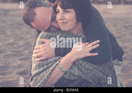 Nette Mann und Frau mittleren Alters Spaß in Liebe am Strand Outdoor. Freizeitbeschäftigung und Big Hug für Liebe Konzept und romantische Szene der Mann umarmen Sie. Sand auf dem Hintergrund Stockfoto