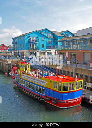 Ein buntes Boot im Eingang das alte Dock in Exmouth, die mittlerweile eine Marina mit modernen Gehäuse, Devon, England, UK umgeben Stockfoto