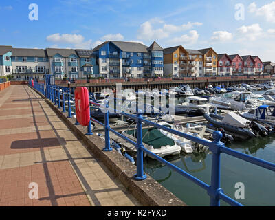 Farbenfrohe, moderne Gehäuse umgibt das alte Dock, jetzt eine Marina, in Exmouth, Devon, England, Großbritannien Stockfoto