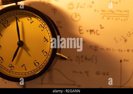 Mal Uhr mit mathematischen Gleichungen Hintergrund vintage Farbton. Stockfoto