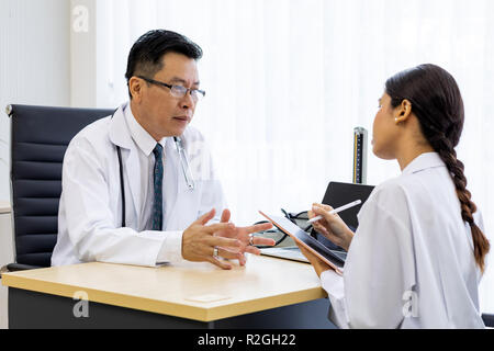 Zwei Ärzte im Krankenhaus die Diagnos des Patienten besprechen Stockfoto