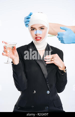 Hände in Handschuhe holding Spritze während Frau mit Cocktail isoliert auf weißem Posing Stockfoto