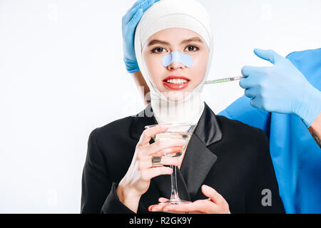 Hände in Handschuhe holding Spritze während Frau mit Cocktail isoliert auf weißem Posing Stockfoto