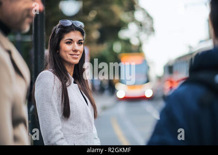 Attraktive Frau, die draußen in der Stadt, die für die Straßenbahn warten. Stockfoto