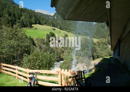 Tiroler Alpenlandschaft wie durch einen Vorhang aus Wasser hinter einem Wasserfall gesehen. Im Stubaital, Tirol, Österreich fotografiert. Stockfoto