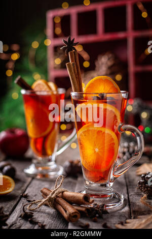 Zwei Gläser Weihnachten Glühwein Rotwein mit den Gewürzen und Früchten auf einem hölzernen rustikalen Tisch. Vertikale Zusammensetzung Stockfoto