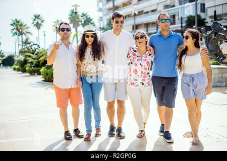 Sechs Freunde wandern, nehmen, lachen und Spaß haben, während des Tages in der städtischen Umgebung Stockfoto