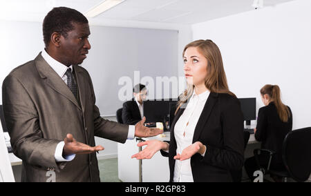 Unglückliche Frau Manager hören wütenden Mann Chef pointinting zu vermisst in Arbeit Stockfoto