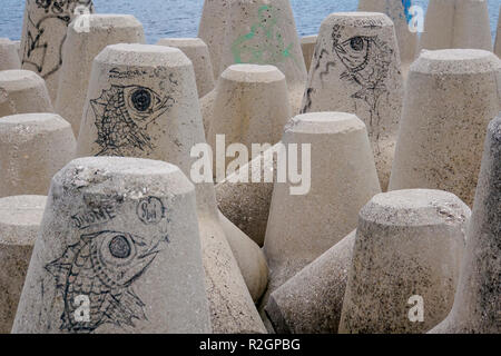 Graffiti auf Beton Sea Wall Bausteine. In Athen, Griechenland, fotografiert. Stockfoto