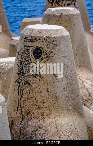 Graffiti auf Beton Sea Wall Bausteine. In Athen, Griechenland, fotografiert. Stockfoto