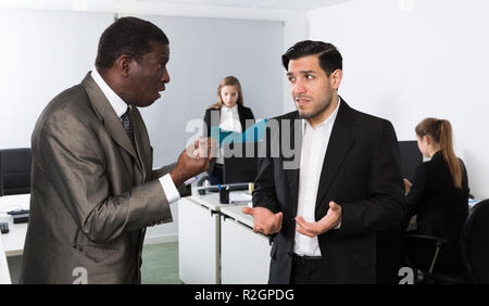 Zornigen Mann Chef pointinting zu vermisst in der Arbeit zu Mann Manager arbeiten im Büro Stockfoto