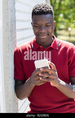 Teenager im Freien Sms vom Mobiltelefon Stockfoto