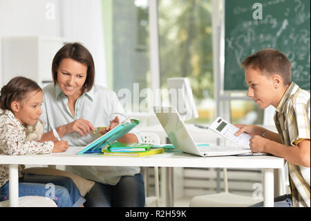 Portrait von Kindern in der Schule im Klassenzimmer mit Lehrer sitzen Stockfoto