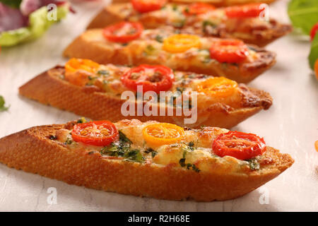 Toast mit Käse Tomatenscheiben und letuce auf einem Stein board Stockfoto