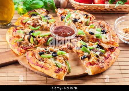 Würzige Pizza mit Hähnchen Gyros, grüner Pfeffer, Oliven und Zwiebeln auf Schneidebrett Stockfoto