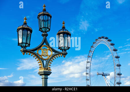 Ein traditionelles Straßenlaterne in London mit dem London Eye und blauer Himmel im Hintergrund Stockfoto