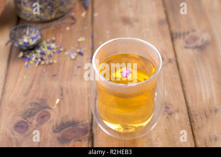 Kaffee in ein Glas mit Lavendel auf einem hölzernen Hintergrund. Heiße Getränke für die Gesundheit Stockfoto