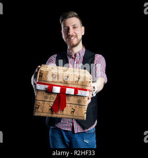 Isolieren Mann hält eine Box der Weihnachtsgeschenke in seinen Händen zum Verkauf. Der Vater gibt Familie Geschenke. Weihnachten Verkauf, Rabatte auf Einkäufe. Hipster Mann Stockfoto