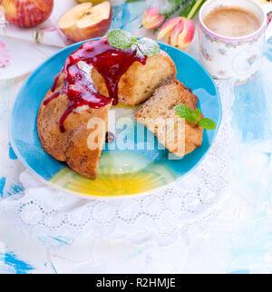 Einen Strauß mit frischen Tulpen. Sweet Home Cupcake mit Zucker. Kaffee in eine Tasse. Äpfel auf dem Tisch Stockfoto