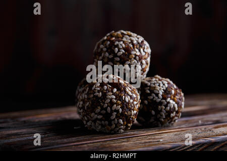 Gesunde Energie Bio Vegetarische beißt mit Nüsse, Datteln, Honig und Sesam auf einem dunklen Hintergrund. Stockfoto