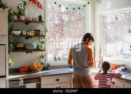 Vater und Sohn in der Küche beim Abwaschen Stockfoto